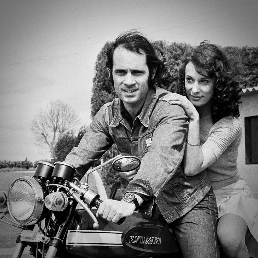 Guy Marchand and Bernadette Lafont posing together on a motorcycle in a vintage photograph.